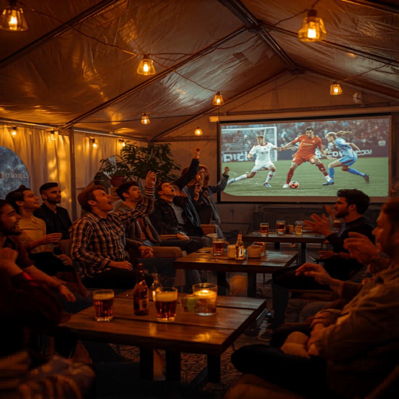 Menschen im Event-Zelt beim Fußballschauen auf der Leinwand